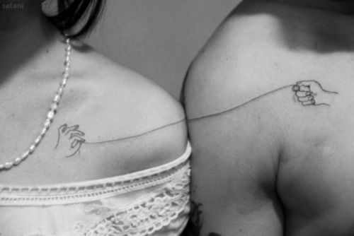 two women wearing bras with tattoos on their backs, one has a small tattoo