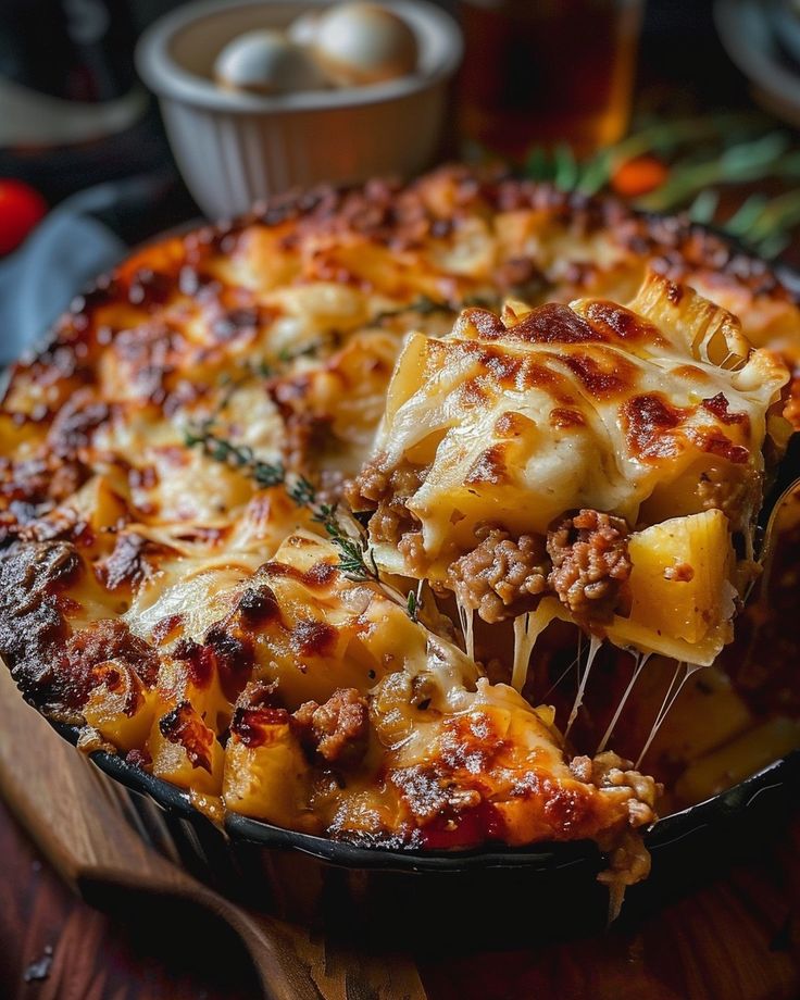 a close up of a pizza in a pan with cheese and meat toppings on it