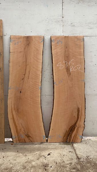 two pieces of wood with writing on them sitting next to each other in front of a wall