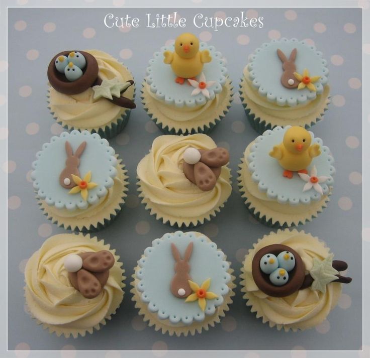 twelve cupcakes decorated with yellow frosting and blue icing are arranged in the shape of bunnies