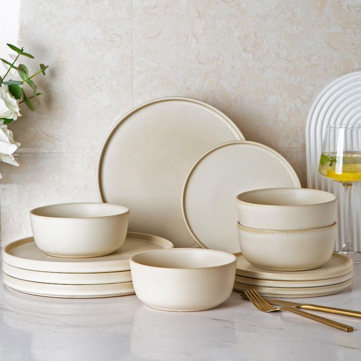 white dishes and cups are arranged on a table