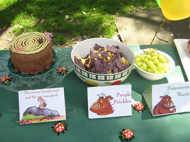 a table topped with lots of food next to a plate of cake and cards on top of it