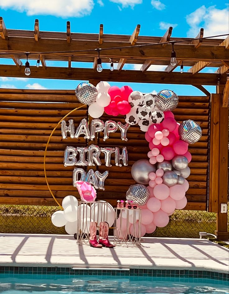 a birthday party with balloons and decorations by the pool