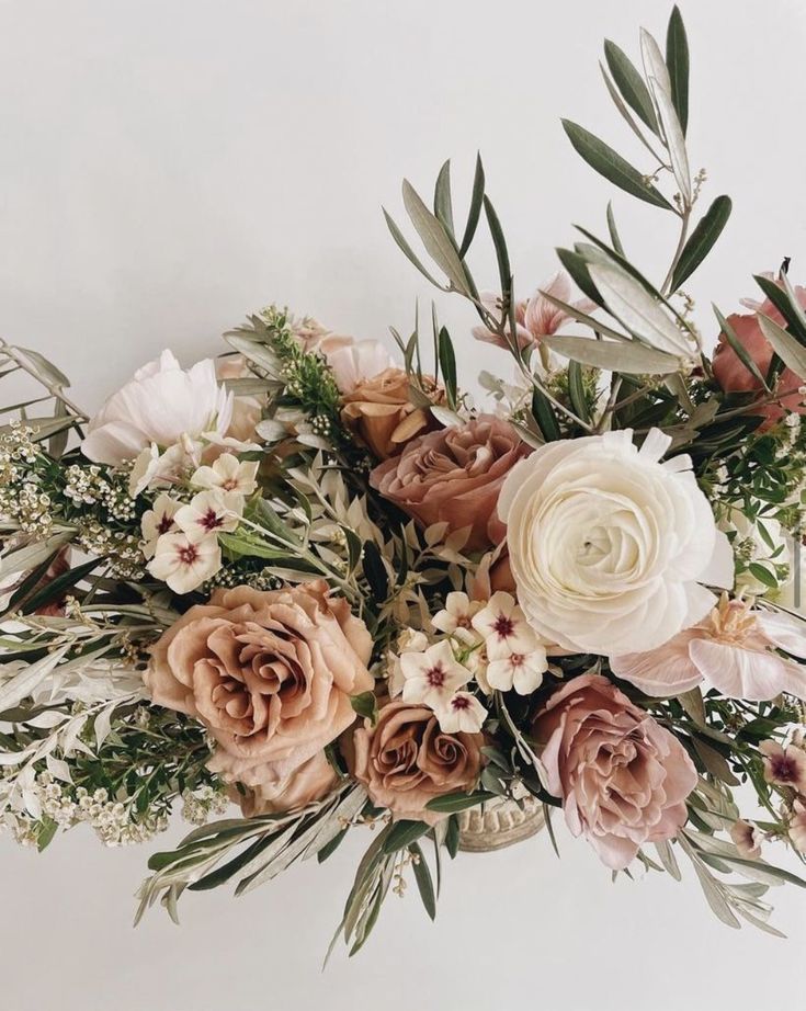 a vase filled with lots of flowers on top of a table