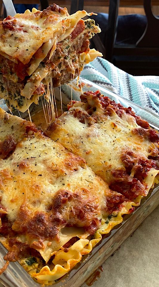 a casserole dish with meat and cheese being lifted from it