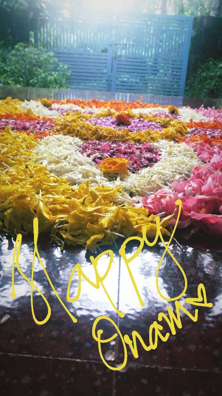 there is a flower arrangement on the ground with words written in yellow and red ink