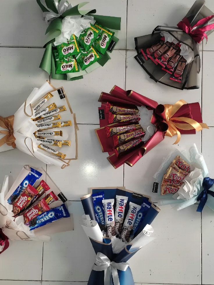 several candy bars wrapped in ribbons on a tiled floor