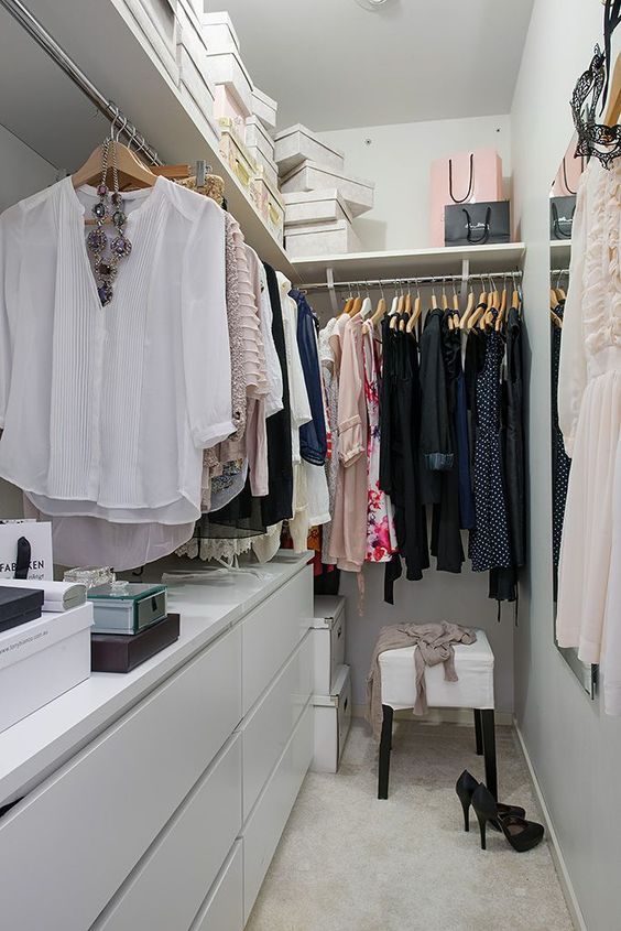 an organized closet with clothes and shoes on hangers, drawers, and other items