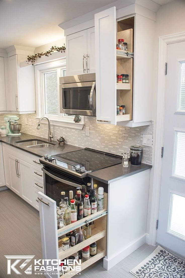 a kitchen with white cabinets and black counter tops