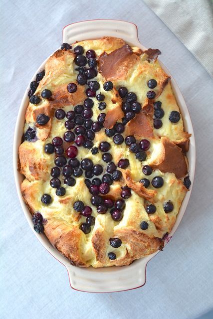 a casserole dish filled with blueberries and bread