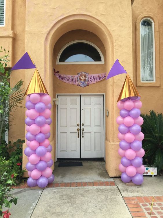 an entrance decorated with purple and gold balloons for a princess birthday or baby's first birthday