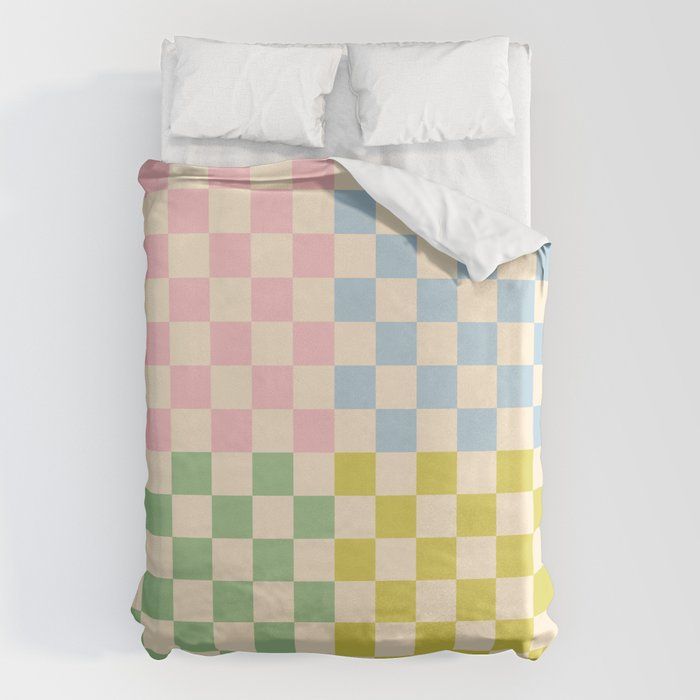 an unmade bed with a checkered comforter and pillows