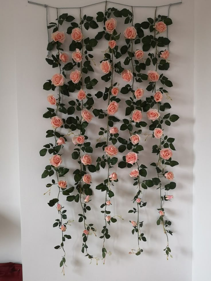 a wall hanging with pink roses and green leaves