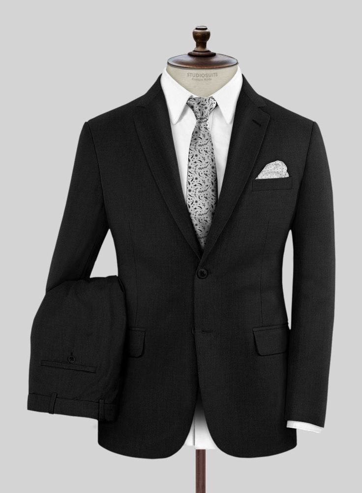 Imbibe the essence of sophistication and refined style with our premium Marco Stretch Deep Black Wool Suit, symbolizing your status as a tasteful connoisseur. Crafted from a luxurious wool blend, this timeless piece boasts a striking solid pattern in a black hue. The fabric's stretch ensures not only comfort but also recognizes the modern man's need for flexibility in a rapidly changing world. Whether conquering the corporate landscape or marking life's milestones, this suit guarantees that you Elegant Black Three-piece Suit For Winter, Elegant Custom Fit Outerwear With Suit Collar, Elegant Outerwear With Suit Collar And Custom Fit, Elegant Custom-fit Outerwear With Suit Collar, Elegant Outerwear With Custom Fit And Suit Collar, Elegant Black Single-breasted Tuxedo, Elegant Winter Three-piece Suit With Suit Collar, Elegant Winter Three-piece Suit, Luxury Black Suit With Hidden Button Closure