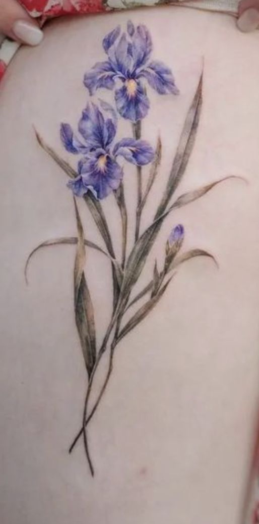 a woman's lower back tattoo with blue flowers on her stomach and the bottom part of her body