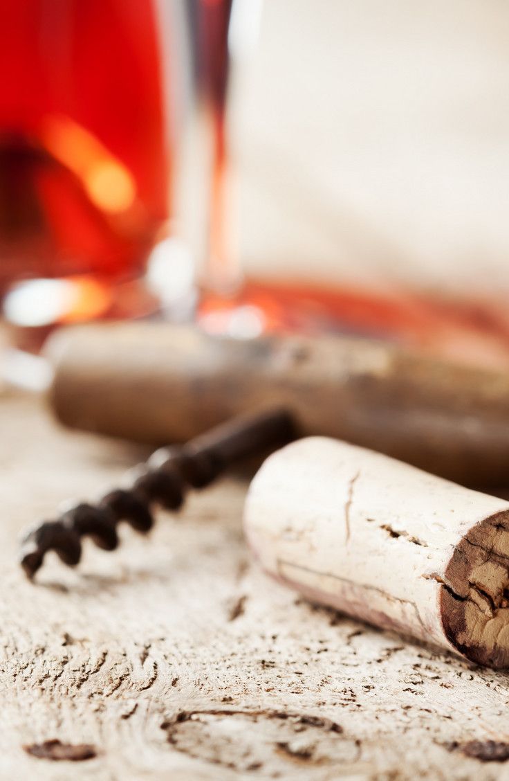 two wine corks sitting on top of a table next to a glass filled with liquid