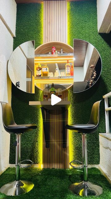 the interior of an apartment with artificial grass on the floor and green walls, as well as two bar stools