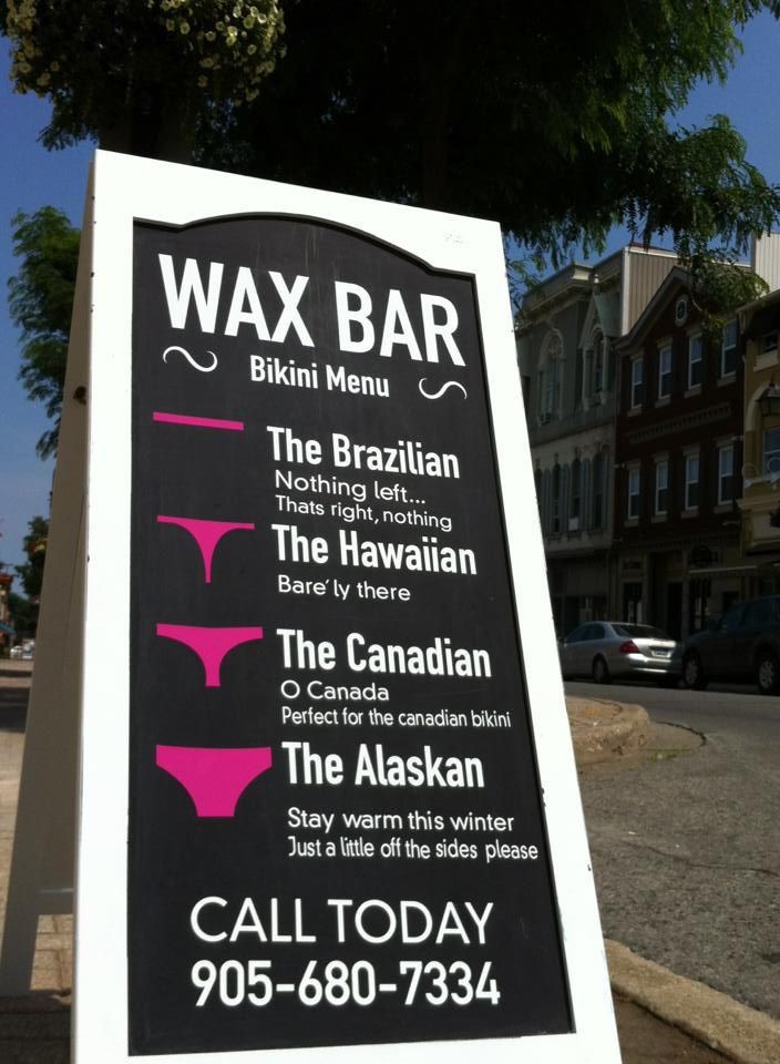 a sign for wax bar on the sidewalk