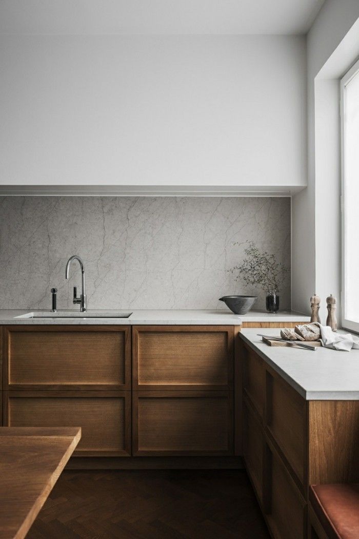 a kitchen with wooden cabinets and white counter tops, along with a window over the sink