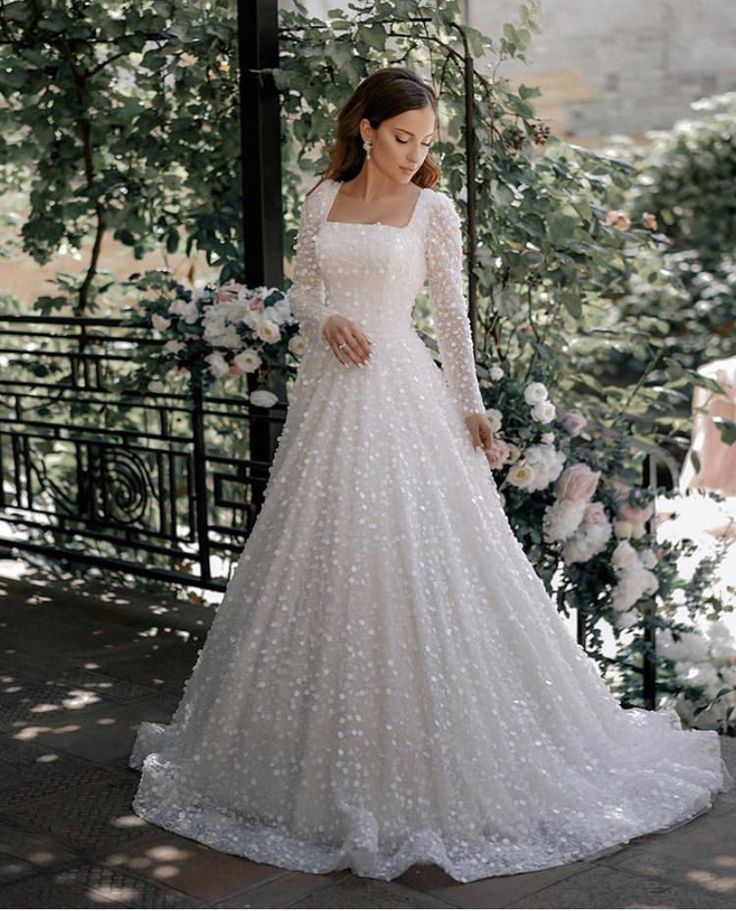 a woman in a wedding dress standing outside