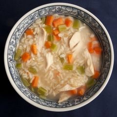 a bowl of chicken and rice soup with carrots