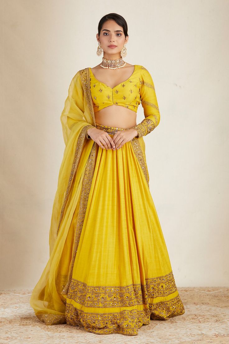 Yellow attached can can lehenga with floral embroidery in bead, cutdana and sitara. Paired with embroidered, padded blouse and embroidered border dupatta.
Components: 3
Pattern: Embroidered
Type Of Work: Bead, Cutdana, Sitara
Neckline: Leaf
Sleeve Type: Long
Fabric: Chanderi
Color: Yellow
Other Details: 
Floral pattern
Back tie-up
Lehenga Length: 44 inches
Occasion: Bride,Wedding - Aza Fashions Haldi Dress For Bride Indian, Haldi Dress For Bride, Zari Lehenga, Astha Narang, Wedding Matching Outfits, Haldi Dress, Yellow Lehenga, Embroidered Lehenga, Beaded Leaf