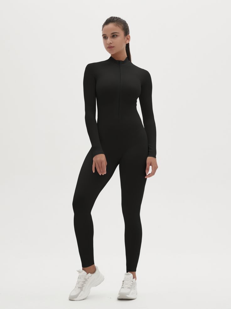 Why We Love It: The Hannah Long Sleeve Zipper Bodysuit is the epitome of sleek, modern activewear. This bodysuit combines functionality with a streamlined design, ensuring you look and feel your best whether you're at the gym or out and about. Fit and Features: Front Zipper Detail: The front zipper allows for easy wear and adjustability, adding a chic element to this versatile piece. Long Sleeves with Thumbholes: Provides added coverage and a secure fit, perfect for cooler weather or intense workouts. Buttery Soft Fabric: This bodysuit feels like a second skin, offering unmatched comfort and flexibility. High Performance: The four-way stretch material ensures maximum freedom of movement, making it ideal for any activity. Moisture-Wicking Technology: Keeps you dry and comfortable, no matter Fitted Sporty Bodysuit For Loungewear, Sporty Fitted Bodysuit For Loungewear, Sleek Fitted Full Length Activewear, Sleek Fitted Activewear For Workout, Sleek High Stretch Black Unitard, Functional Second-skin Activewear For Gym, Second-skin Functional Activewear For Gym, Sleek High Stretch Jumpsuits And Rompers, Sporty Second-skin Bodysuit For Loungewear