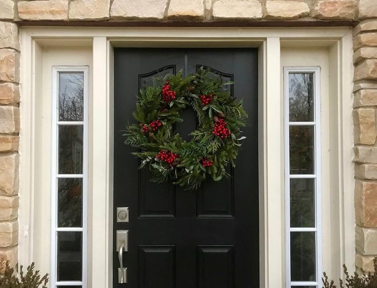 a black front door with a wreath on it