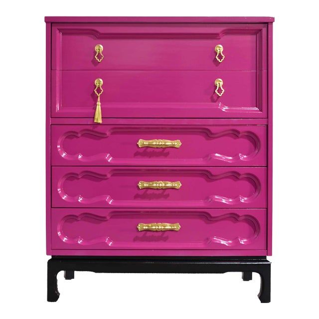 a pink dresser with gold handles on it's top and bottom drawers, against a white background