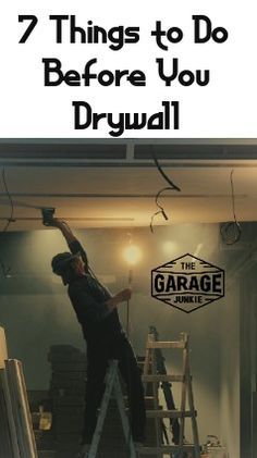 a man on a ladder painting the ceiling in his garage with text overlay that reads, 7 things to do before you drywall