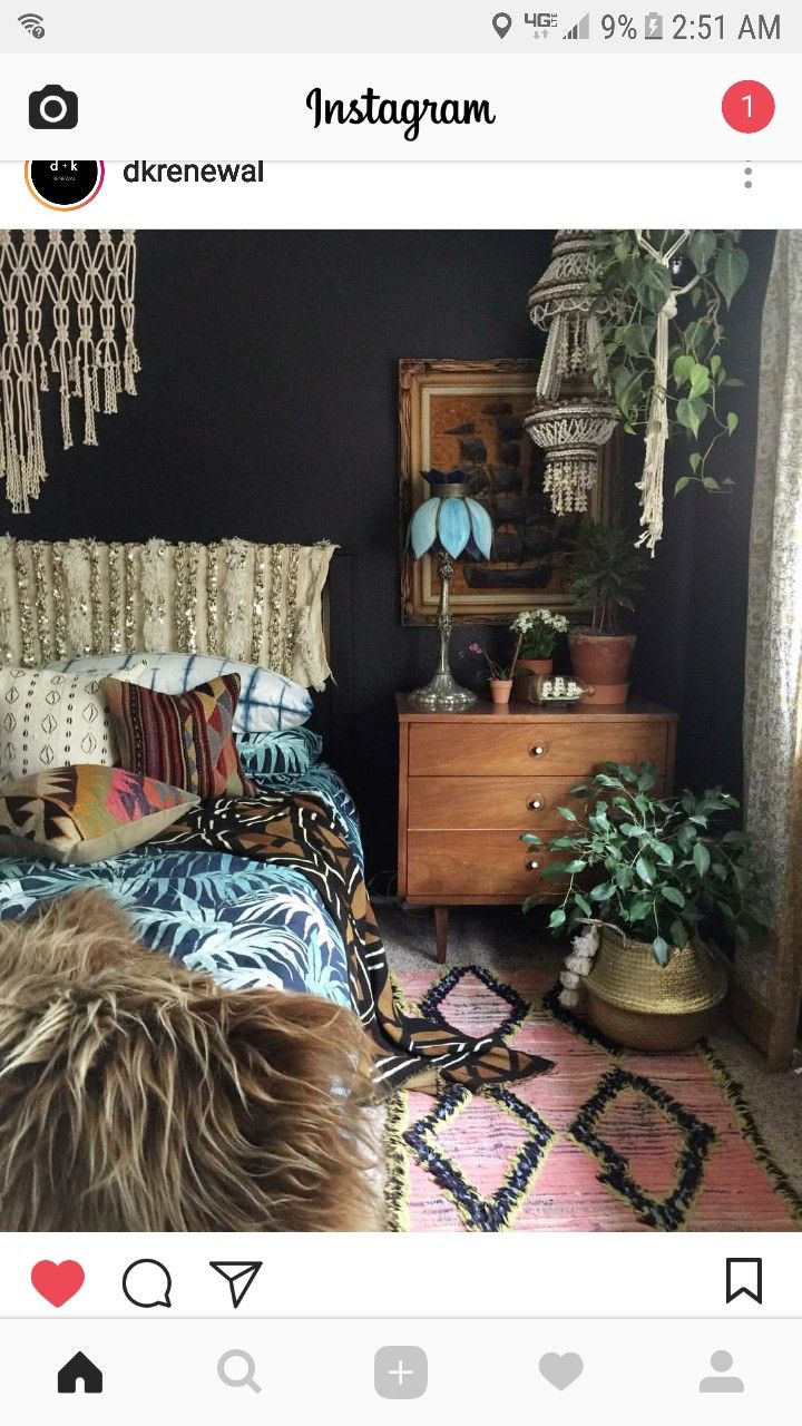 a bed room with a neatly made bed next to a dresser and potted plants