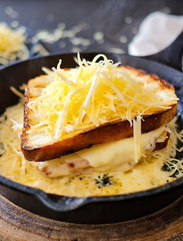 a close up of a plate of food with cheese on top and bread in the middle