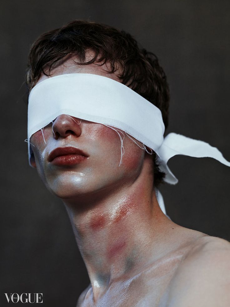 a man with white paint on his face and blindfold