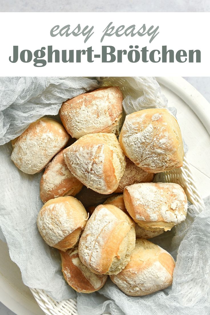 a white plate topped with loaves of bread on top of a cloth covered table