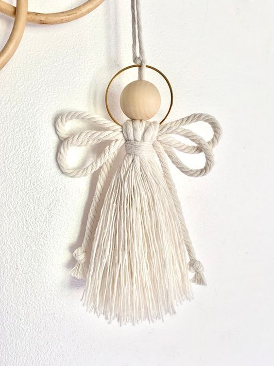 an angel ornament hanging on a wall next to two circular rings with handles