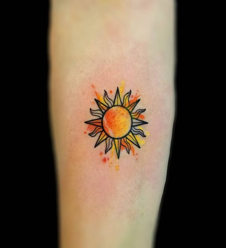 a small sun tattoo on the leg