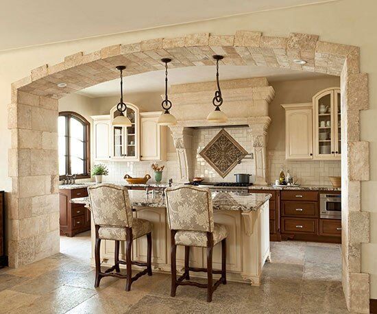 a kitchen with an archway leading into the living room and dining area, as well as two bar stools