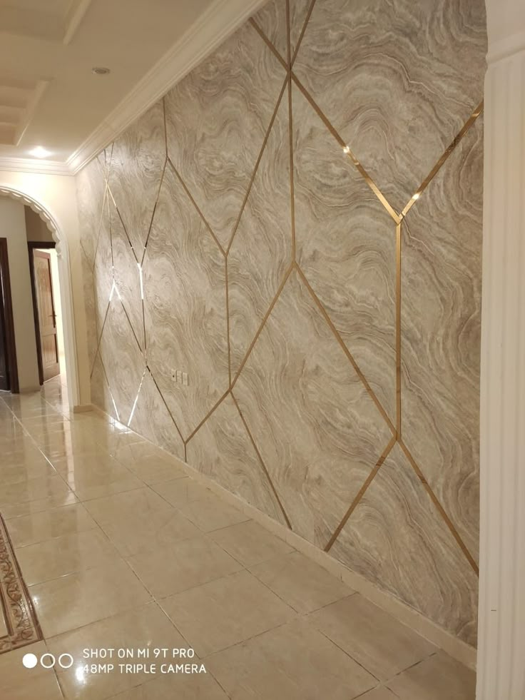 a hallway with marble walls and flooring in an upscale home or business building,