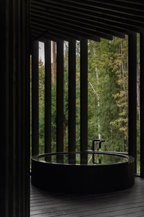 an outdoor jacuzzi tub on a wooden deck with trees in the back ground