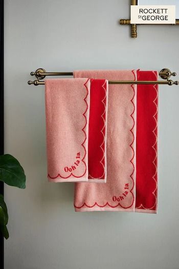 three red towels hanging on a towel rack