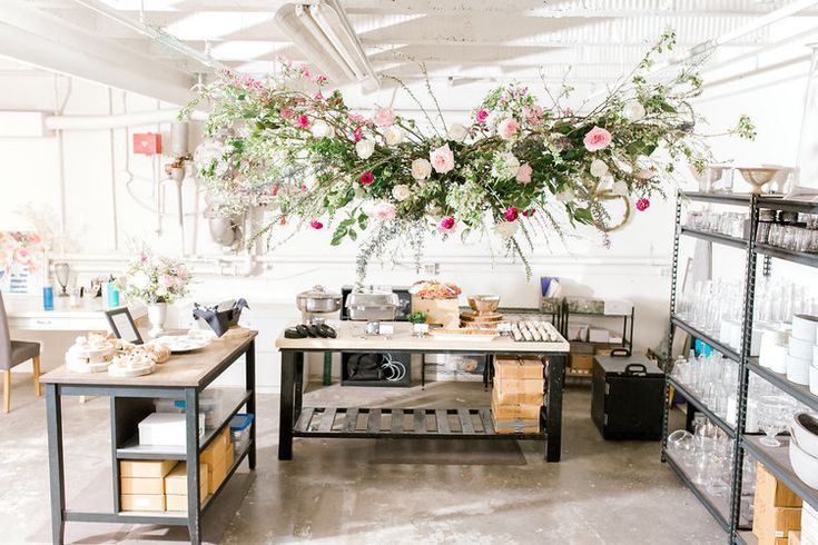 a flower shop with flowers hanging from the ceiling and shelves full of items on display