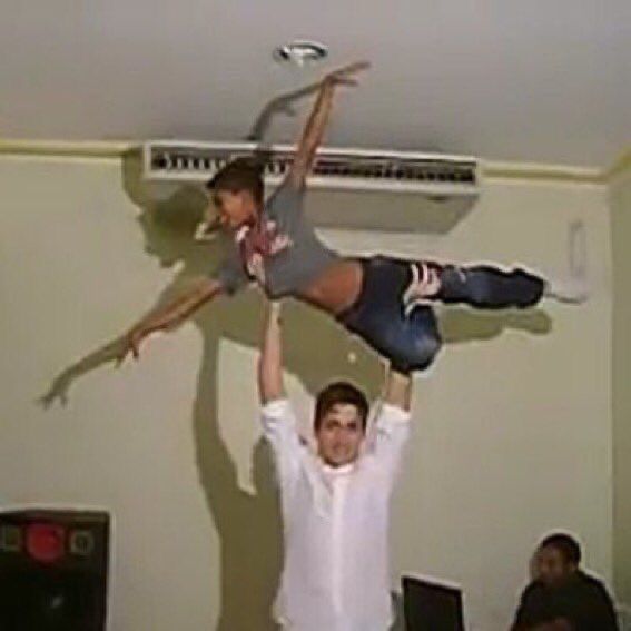 two people are doing tricks on the ceiling