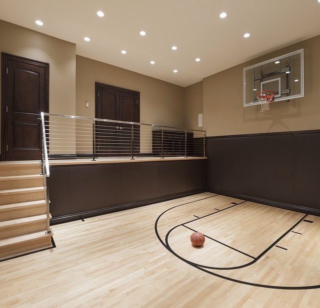 an indoor basketball court in the middle of a room with hardwood floors and hard wood flooring