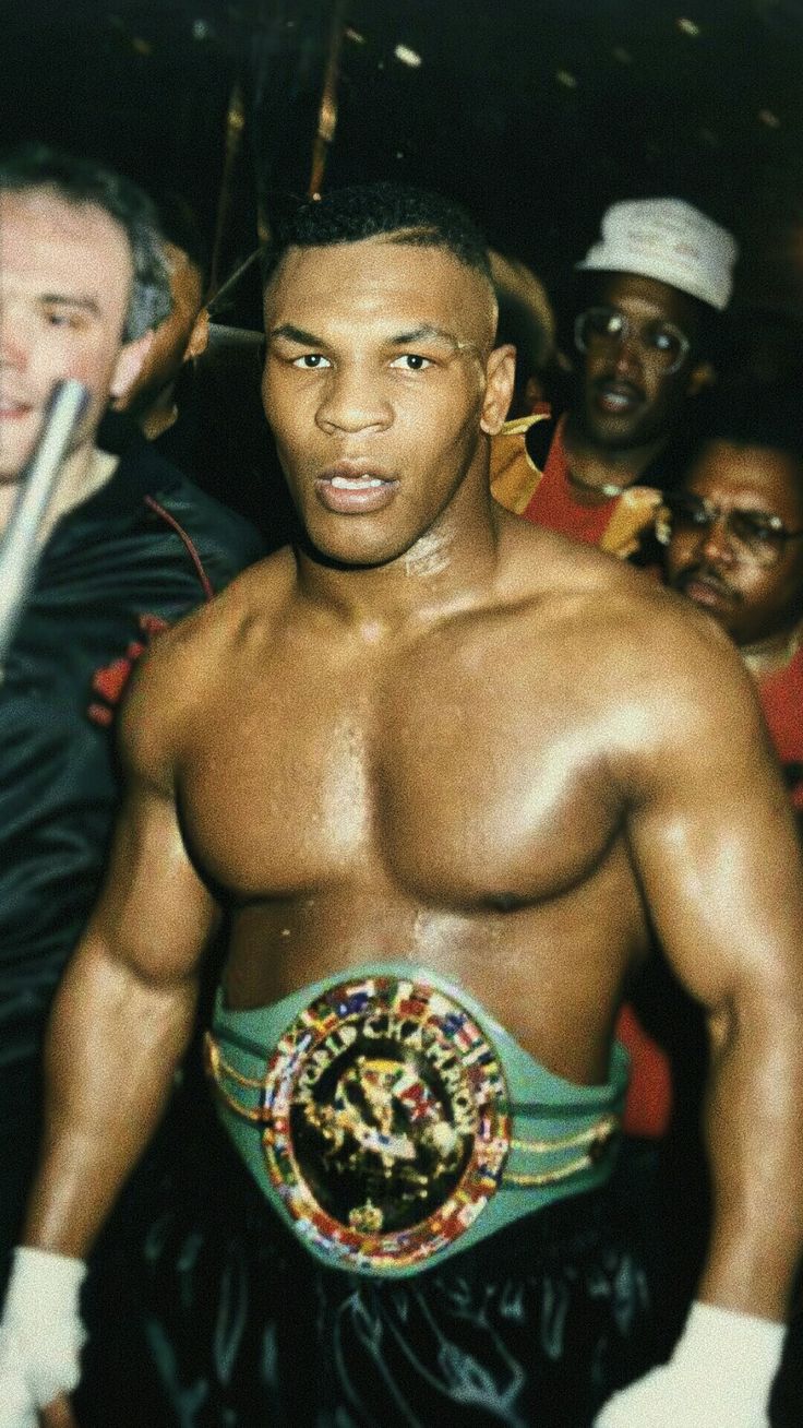 a man standing in front of a group of people wearing boxing gloves and holding a bat