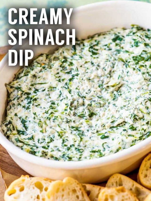 creamy spinach dip in a white bowl with crackers on the side and text overlay