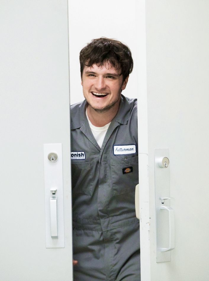 a man in overalls is smiling through the door