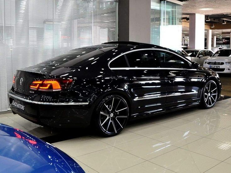 a black car is parked in a showroom