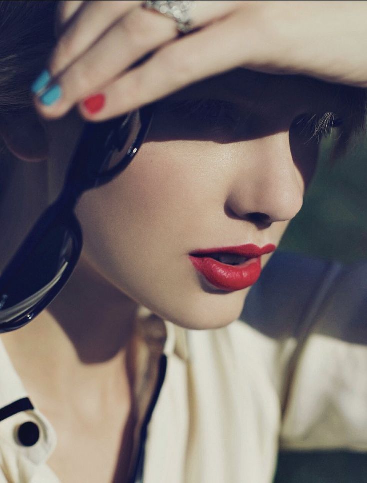 a woman with red lipstick and ring on her finger