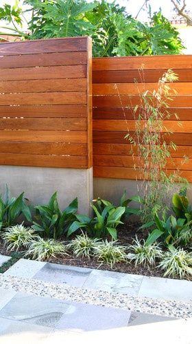 a wooden fence in front of some plants