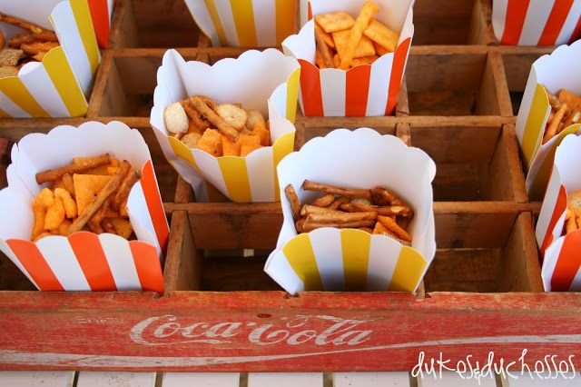 several boxes filled with different types of food sitting on top of a wooden table in front of a coca cola sign